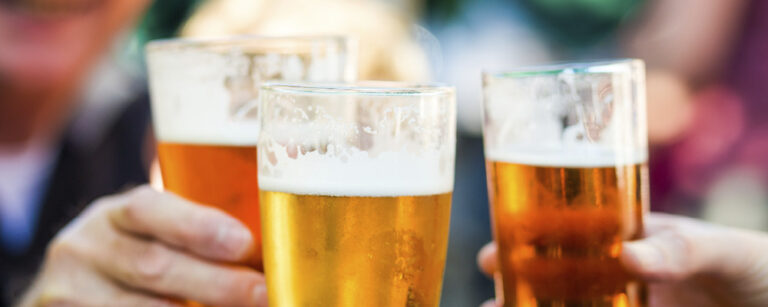 Three beer glasses clinking together