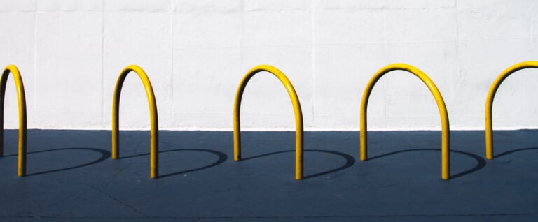 Yellow croquet wickets casting shadows on the ground