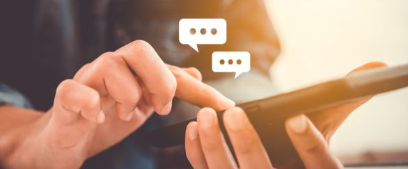 Person messaging on smartphone with typing bubbles