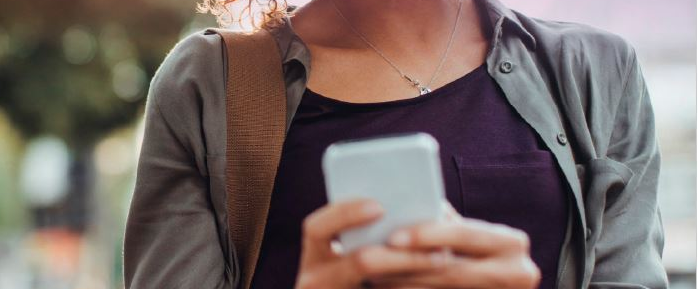View of woman's torso as she uses smartphone